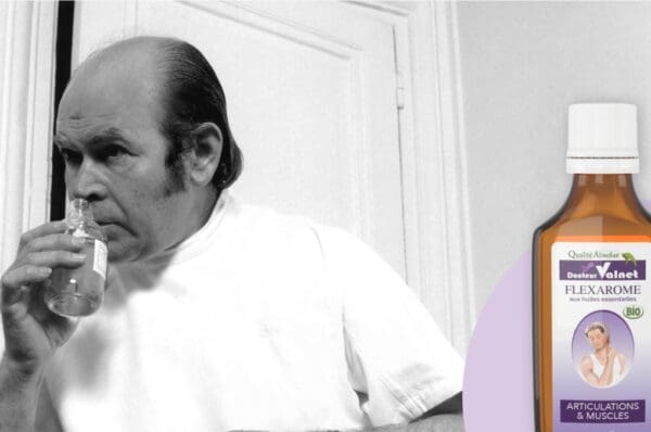 Jean Valnet dans son laboratoire, tenant un flacon d'huiles essentielles